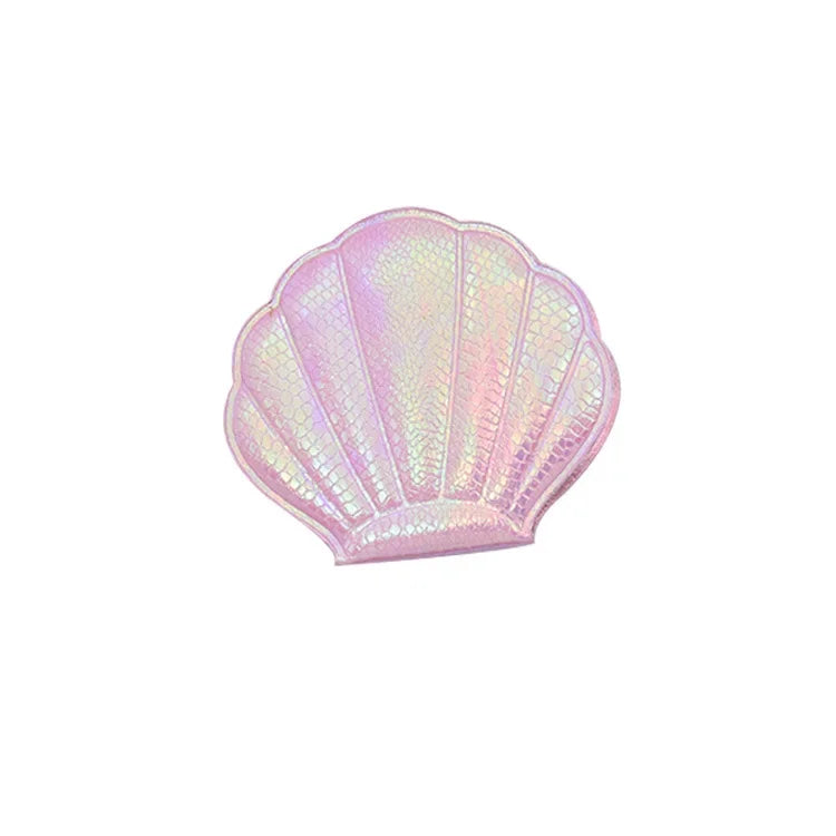 A pink iridescent seashell-shaped portable magnifying makeup mirror.
