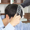 A person is using a gray wide-tooth hair styling comb on their dark hair.