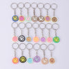 A set of 20 colorful cartoon smile face keychains hanging from split rings.