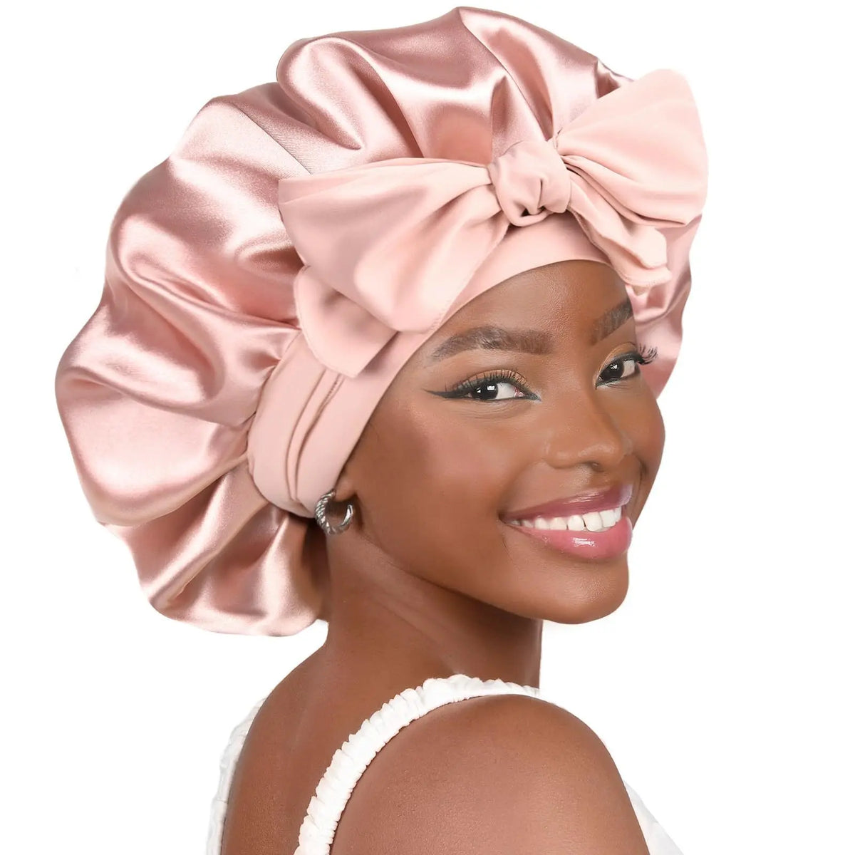 Eine Frau modelliert eine rosa Satin-Haube mit doppeltem Halstuch und einer großen Schleife.