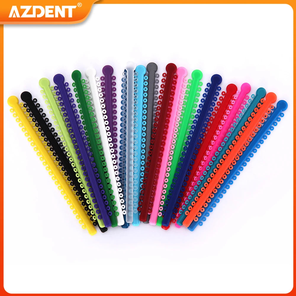 A collection of colorful dental orthodontic elastic ligature ties arranged in a row.