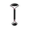 A rose gold and black jade gua sha facial stone tool with a handle and a rounded head.