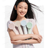 A woman holds a professional high-speed hair dryer with temperature control, featuring multiple colored nozzles.