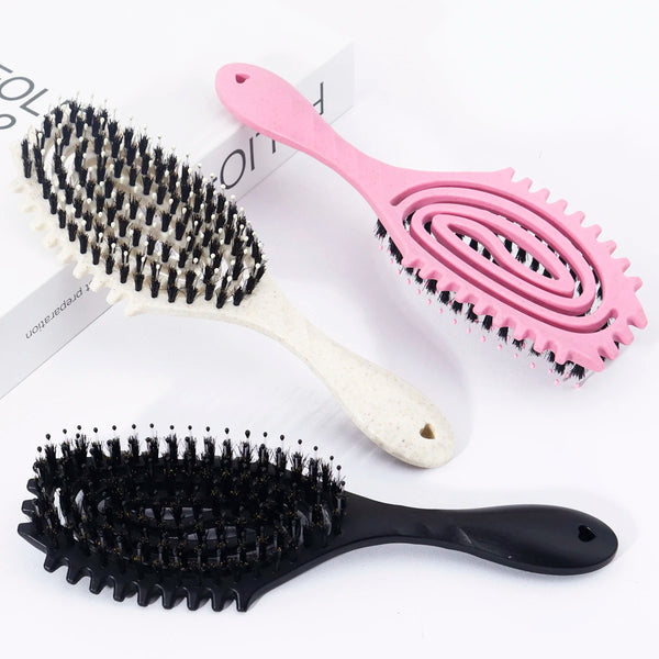 A collection of pink and black styling combs, including a large arc comb and a small round brush comb.