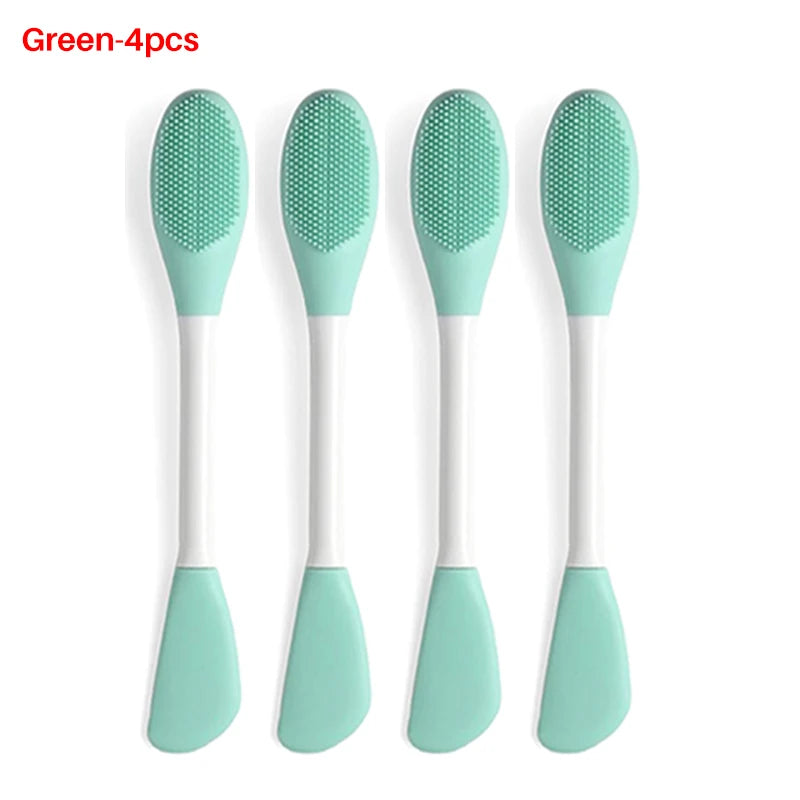 A set of four green silicone facial brushes for exfoliation with white handles.