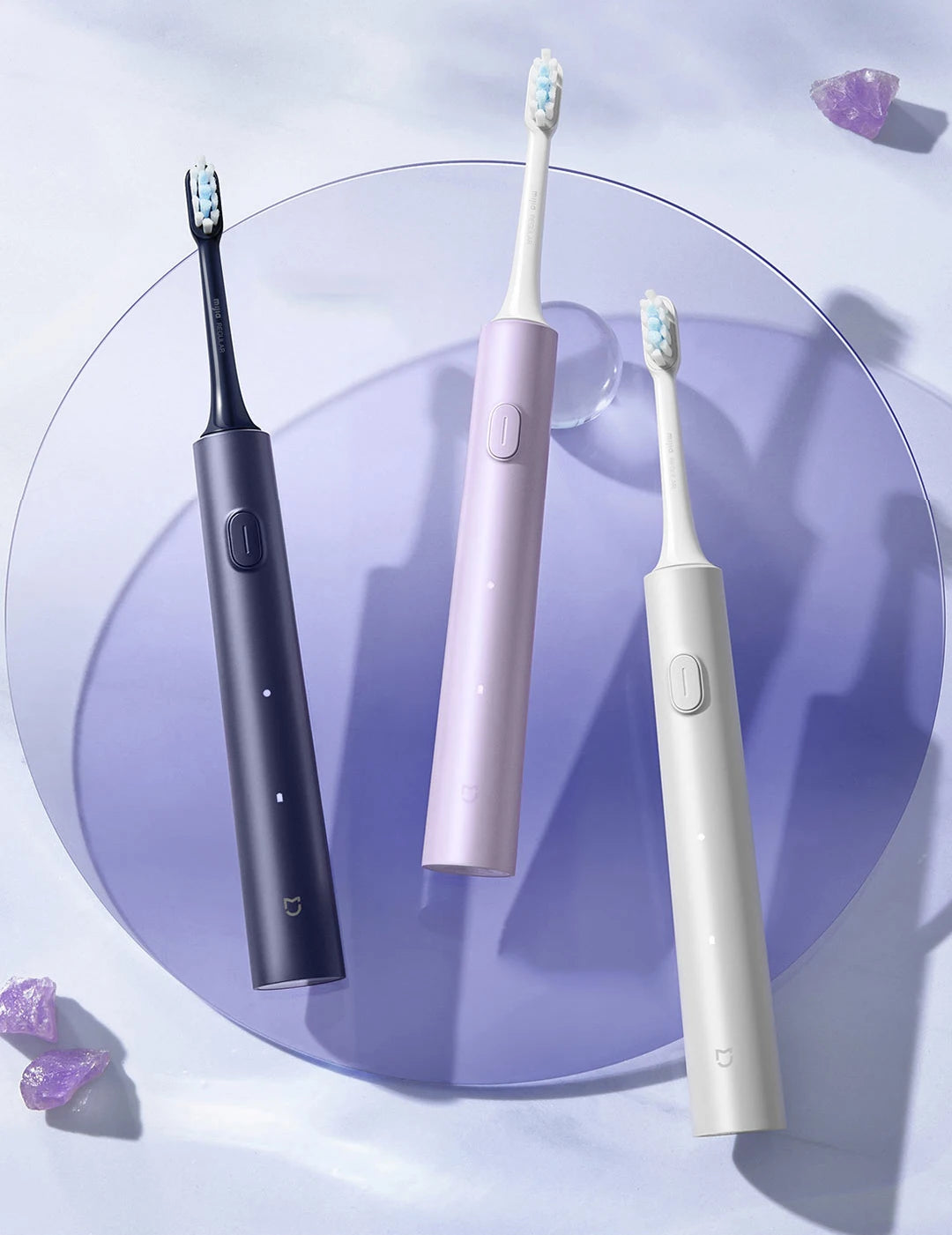 A purple electric toothbrush and a white electric toothbrush are displayed on a light purple surface.