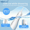 A white portable water flosser oral irrigator is shown spraying water while showering, highlighting its IPX7 waterproof panel