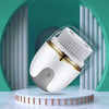 A white electric facial cleanser brush is displayed on a round wooden stand against a teal background.
