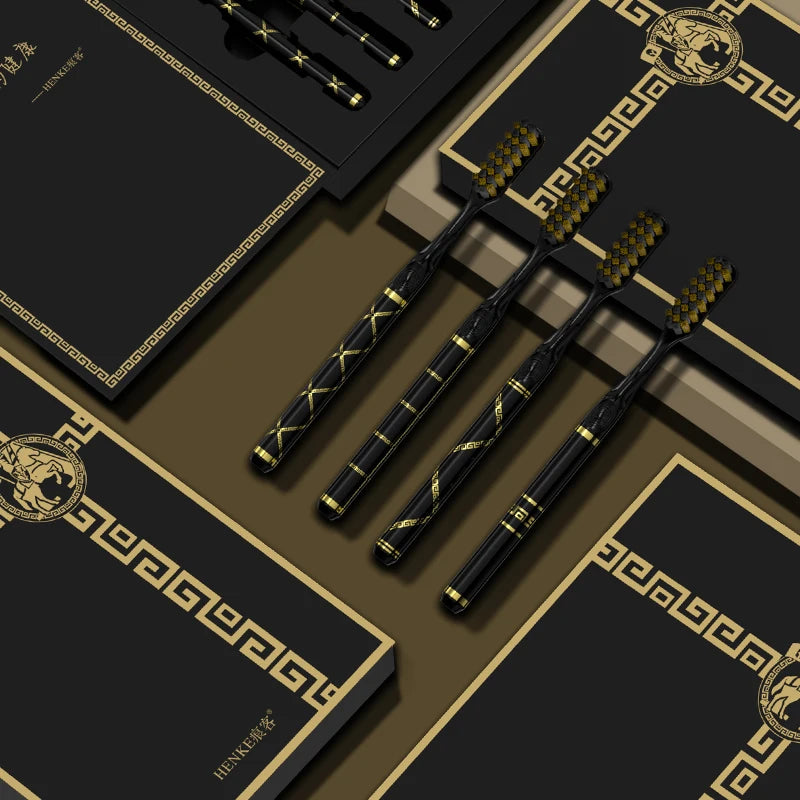 A set of black toothbrushes with gold accents displayed on dark brown and black packaging.