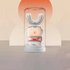 A white electric toothbrush for kids with a clear head and pink accents is displayed against an orange background.