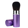Un seul pinceau de maquillage noir rétractable avec une ferule argentée et une boîte cylindrique violette.