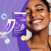A woman smiling with teeth whitening patches applied to her smile.