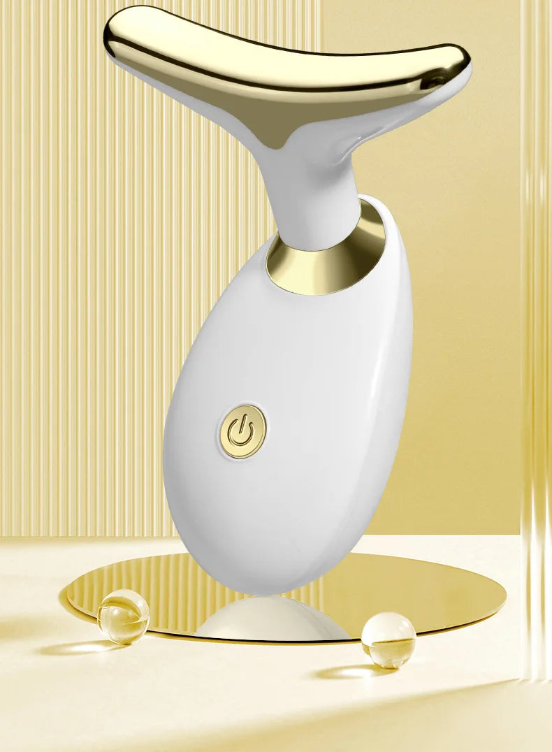 A white electric facial lifting massager with a gold accent, shown against a light background.