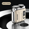 A close-up of a Desert Titanium electric shaver in a beige and silver finish resting on a dark surface.