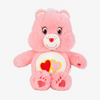 A pink Classic Care Bears plush stuffed animal doll with a white belly featuring red and yellow hearts.