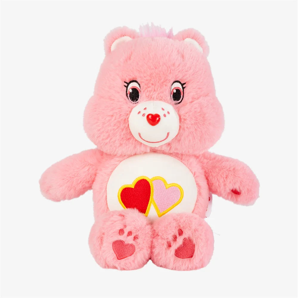 A pink Classic Care Bears plush stuffed animal doll with a white belly featuring red and yellow hearts.