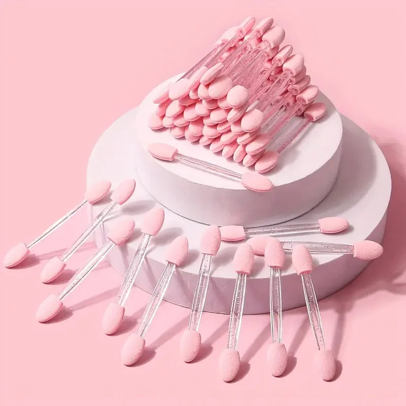 A pink double-sided nail art brush with sponge applicator displayed on a white stand.
