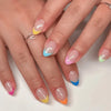A hand displays various pink, yellow, and blue flower-themed press-on nails on fingers.