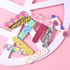 A collection of colorful double-sided nail files and buffing blocks arranged on a pink background.