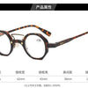 Une paire de lunettes de lecture rondes à monture marron sur fond blanc.