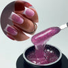 Gros plan d'une main avec des extensions de ongles violet scintillants et une petite quantité de gel pour ongles violet appli