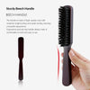 A close-up view of a dark brown wooden boar bristle hair and beard brush being held by a hand.