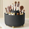 A black rotating makeup organizer holding various makeup brushes and tools.