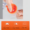 A hand is squeezing an orange medical compression nebulizer device to produce fog.