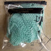 A package containing a green African bath sponge made of net material.