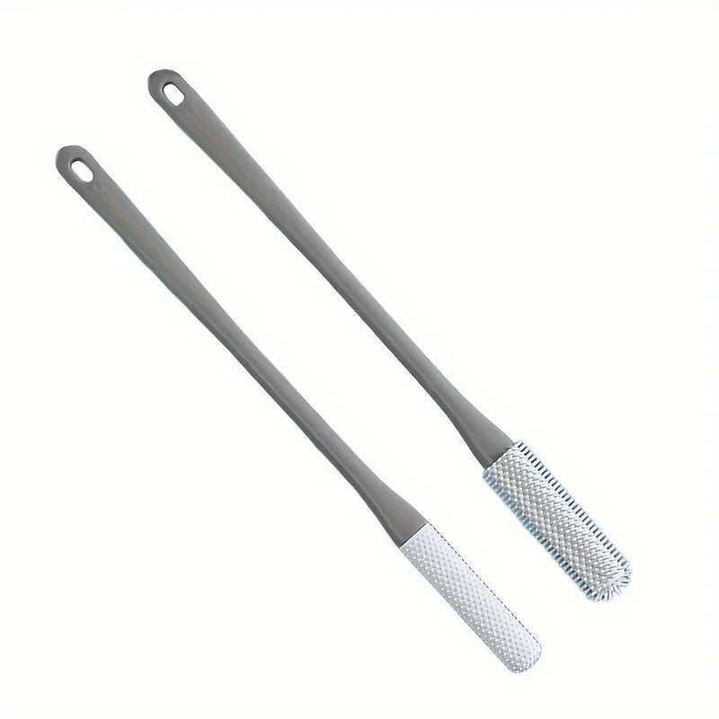 A long-handled manual foot scrubber with a smooth handle and a textured cleaning pad.