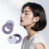A close-up of a woman wearing a purple silicone earplug, demonstrating noise reduction and comfort.