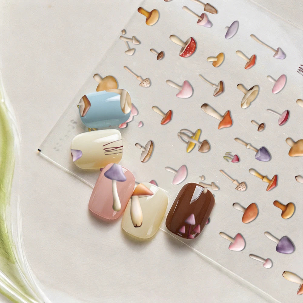A collection of watercolor mushroom nail art stickers in various pastel and earthy tones arranged on a clear sheet.