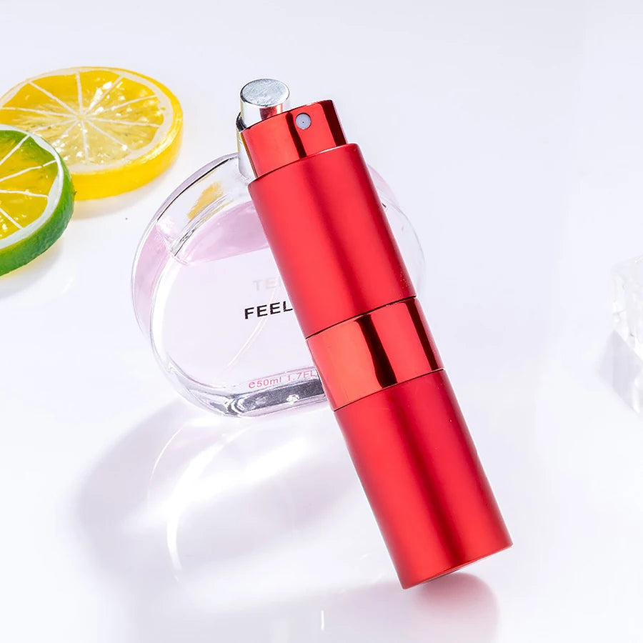 Flacon de parfum rouge avec bouchon argenté et bouteille en verre, à côté d'une tranche de citron et de lime.