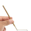 A hand holds a professional stainless steel lash extension mirror set with a gold-toned handle and a rectangular mirror plate