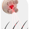 A pink electric handheld scalp massager emitting gentle red light onto skin tissue.