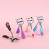 A set of five stainless steel eyelash curlers in various pastel colors including pink purple and blue displayed on a pink bac