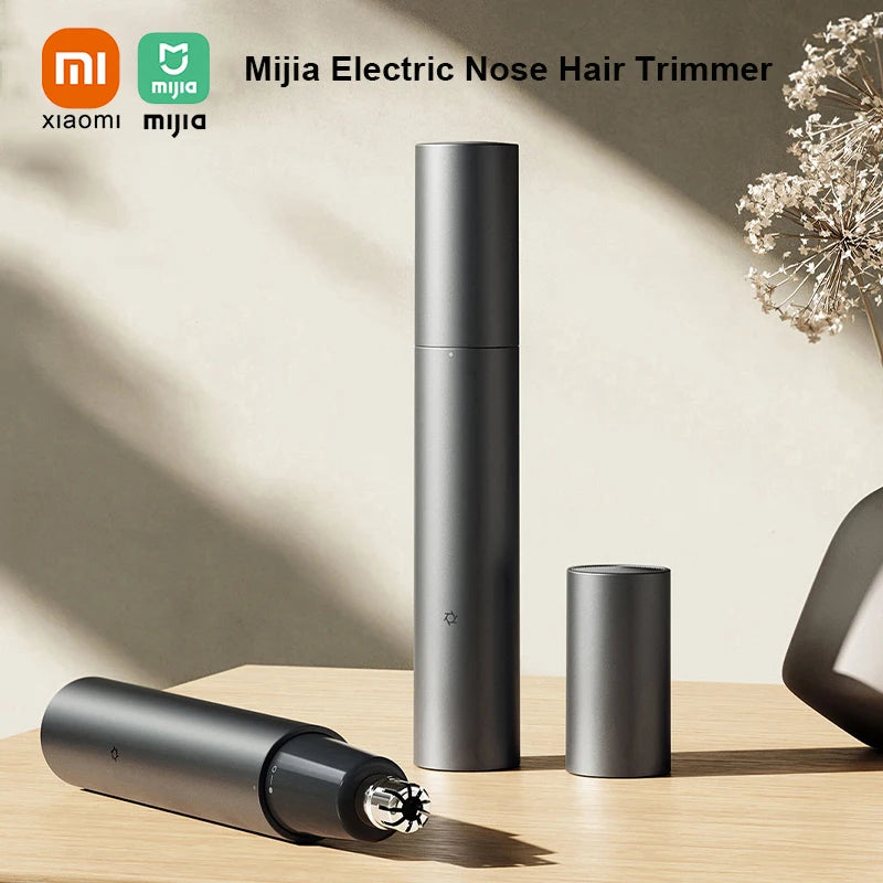 A tall, cylindrical electric nose hair trimmer in matte black is shown next to a smaller version and a separate trimmer head 