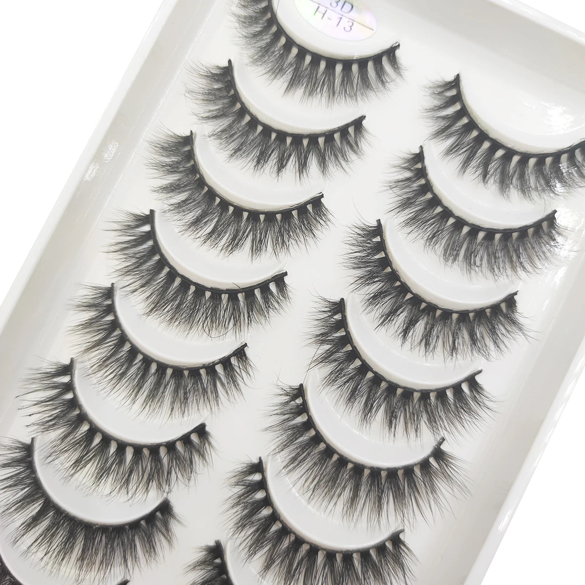 A tray of natural 3D mink false eyelashes displayed for sale.