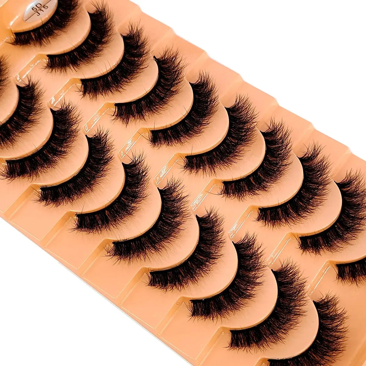Un plateau de faux cils de renard fait main, couleur pêche ou nude, disposés pour l'exposition.