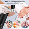 Hands applying a spray to create gradient nails using a portable airbrush kit for nail art