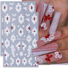A set of two white floral nail stickers featuring delicate flowers and leaves on a light blue background.