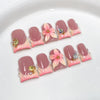 Un set de uñas postizas de perla rosa nude con flores, mostradas sobre un fondo blanco.