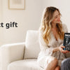 A couple is looking at a black grooming kit for men and body grooming on a sofa.