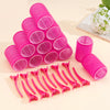 A collection of bright pink self-grip hair rollers arranged in a pyramid and a row on a light background.