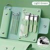 Light green manicure set with metal tools and clipper on a wooden board