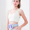 A woman is demonstrating an adjustable electric massage ring for muscle relief on her abdomen.