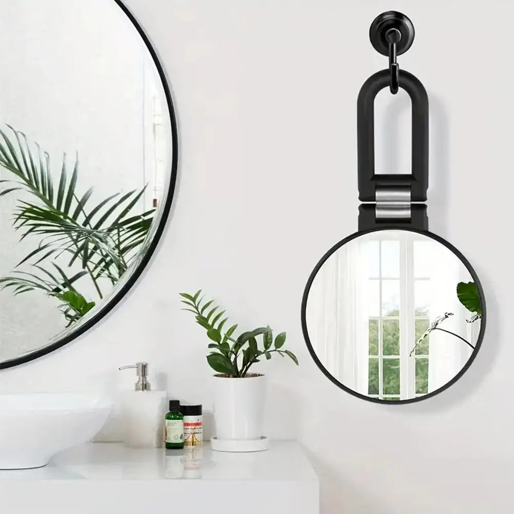 Miroir de voyage double face noir suspendu au-dessus d'un lavabo de salle de bain.