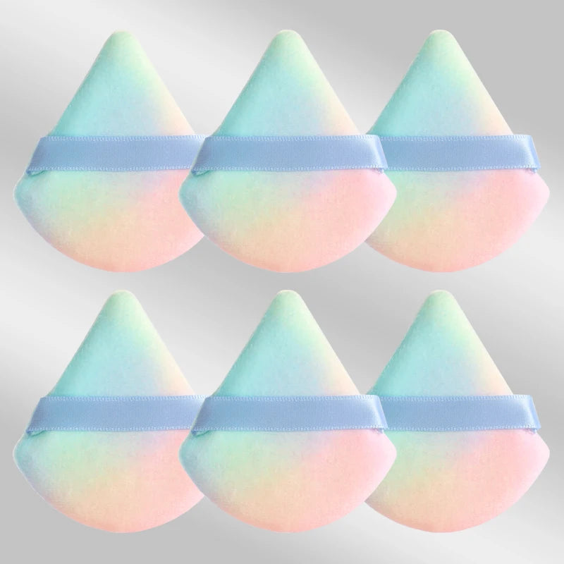 Un set de six éponges de maquillage triangulaires rose pastel et bleu clair avec des élastiques lavande.