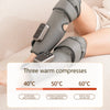 A person is using a gray cordless heated compress on their leg for muscle relief.