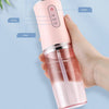 A hand holds a pink portable oral irrigator demonstrating three-speed mode adjustment for teeth cleaning.